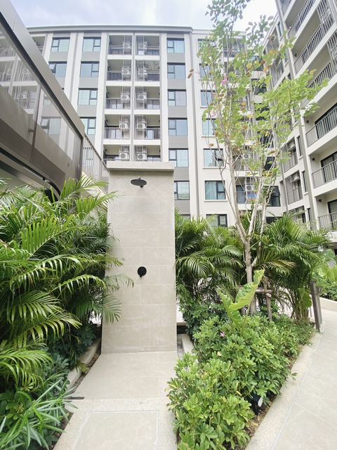 Building exterior with tropical landscaping and outdoor shower